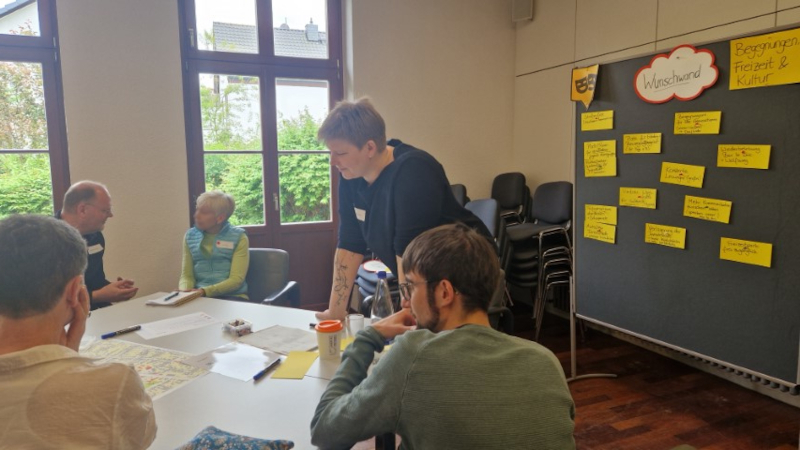 Workshop mit Verwaltungsmitarbeitenden, im Hintergrund eine Pinnwand mit Wünschen für die Innenstadt